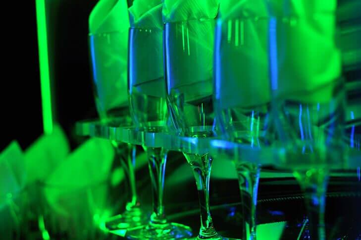 champagne glasses against neon lights